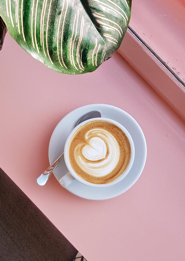 top view of a breve coffee on a pink countertop
