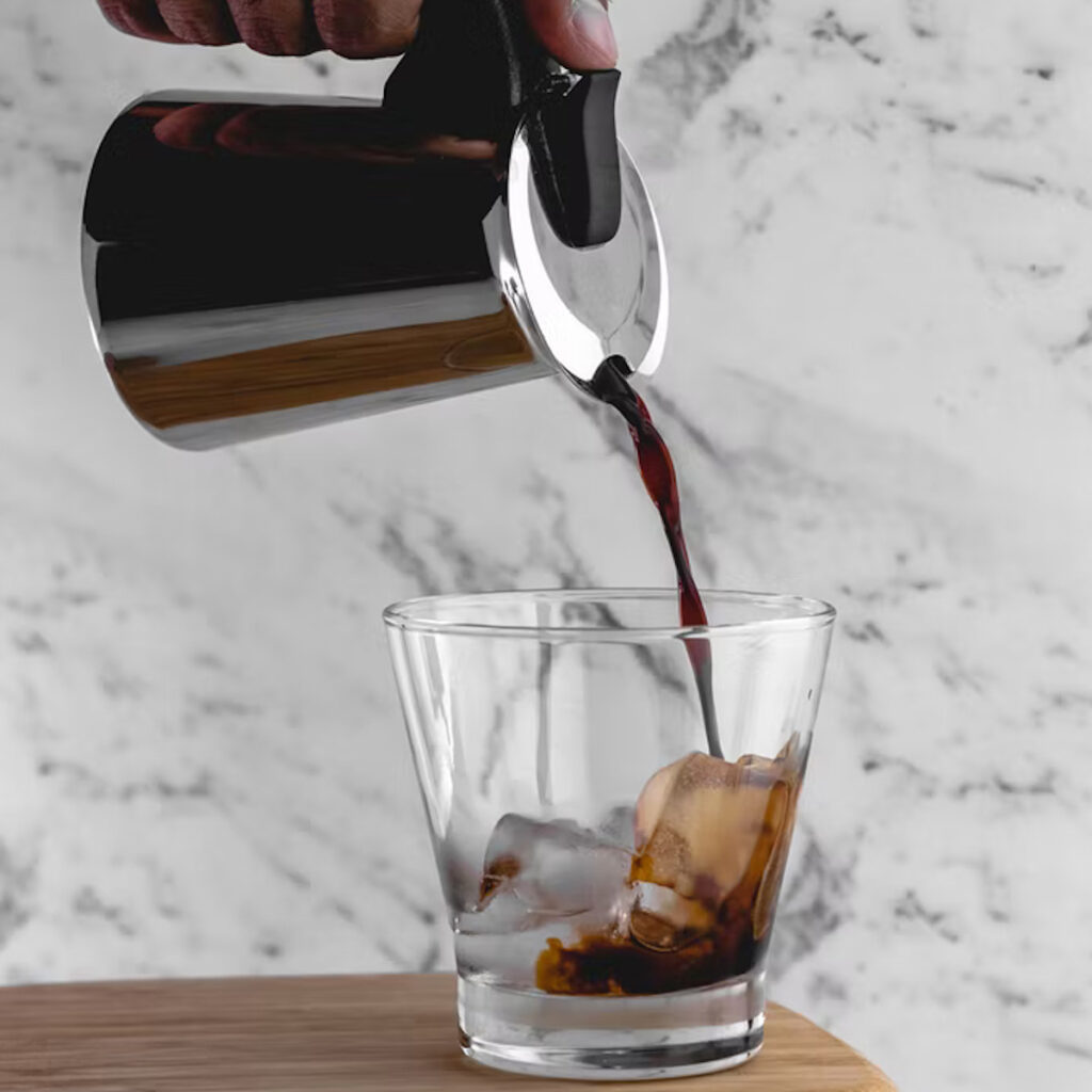 cold brew coffee being poured into a glass