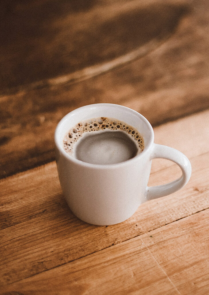 small white coffee mug with black coffee