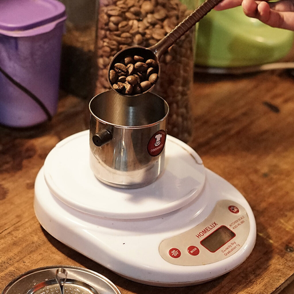 coffee beans getting weighed on a scale