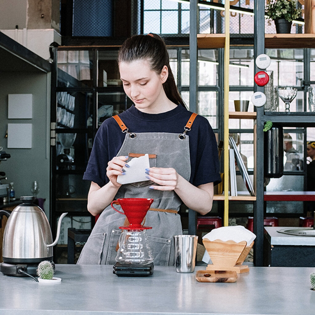 young woman filtering coffee