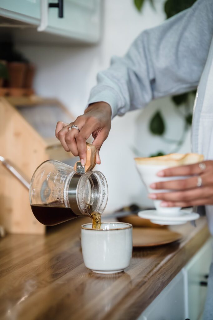 pouring coffee from glass coffee pot into a mug