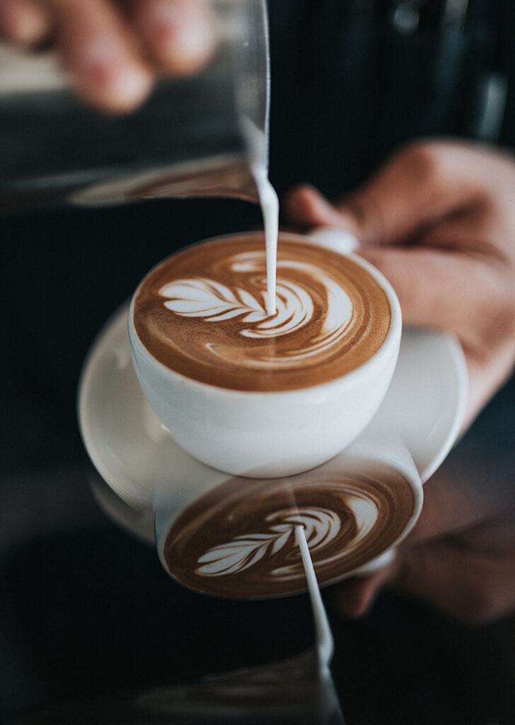 frothed cream pouring onto a latte