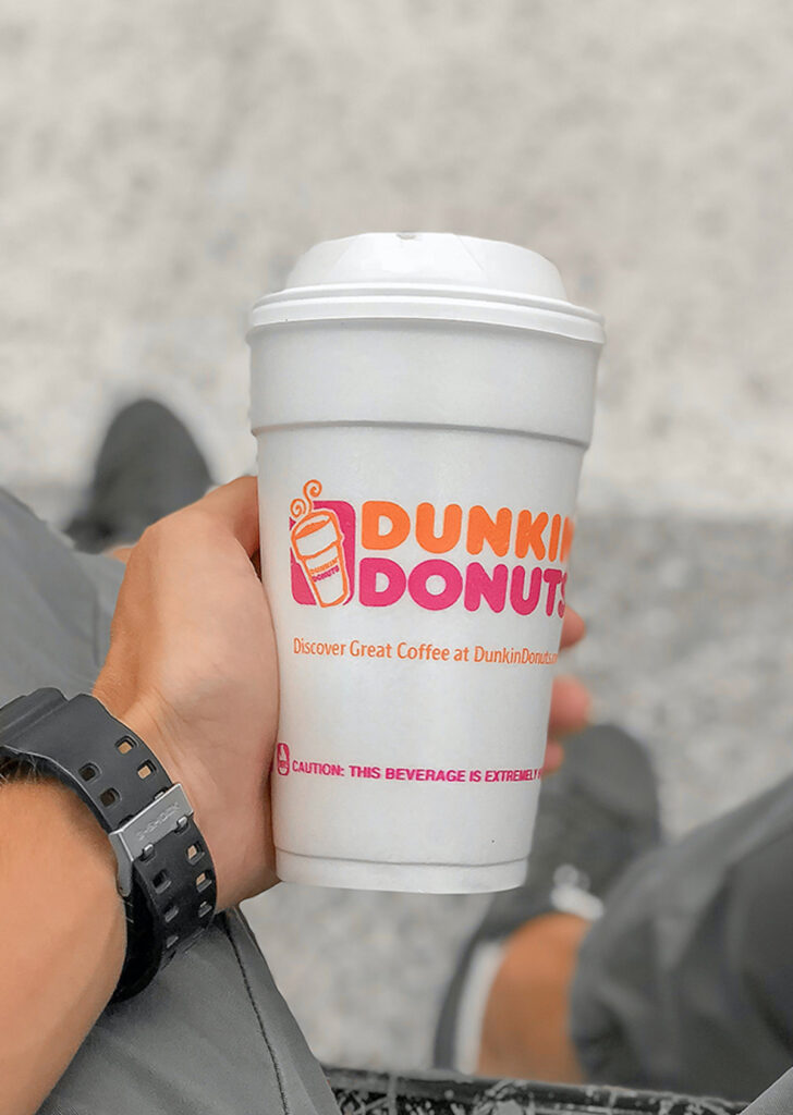 hand holding styrofoam dunkin' donuts coffee cup