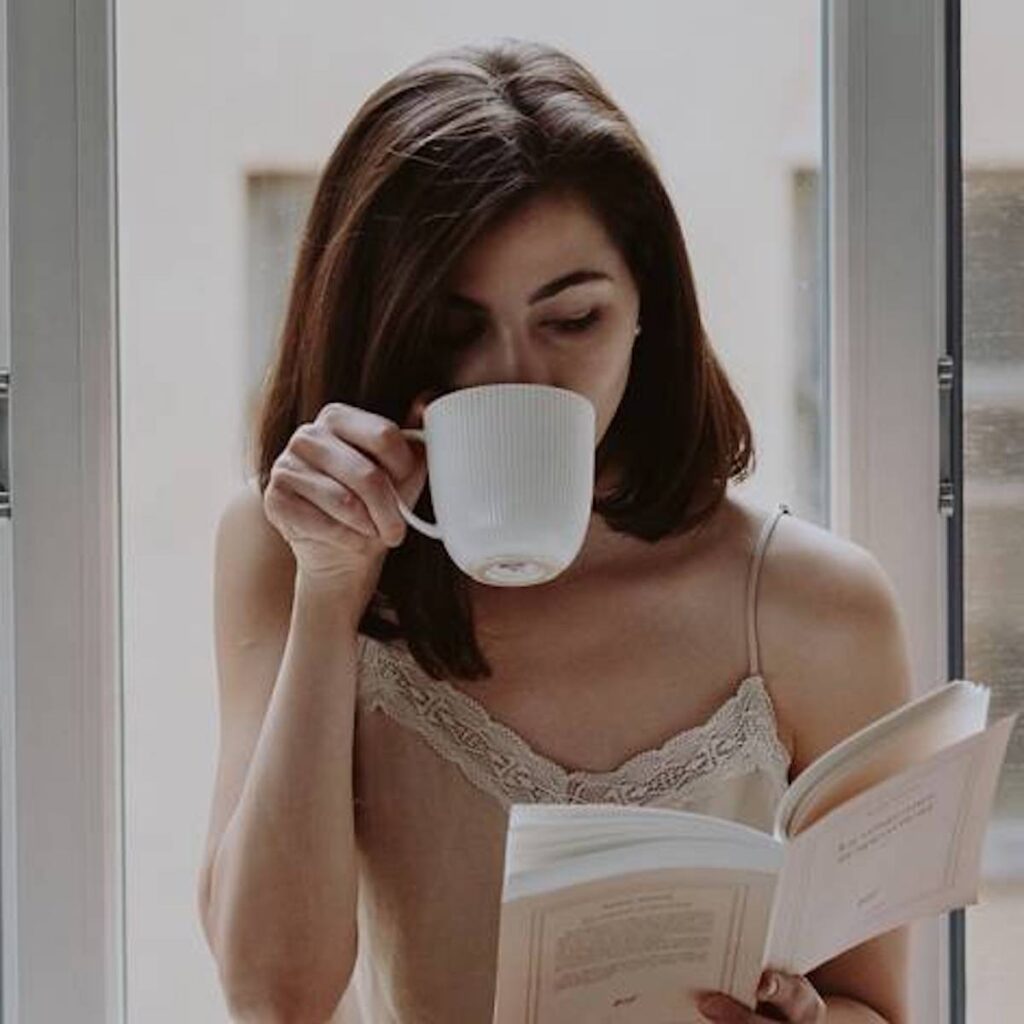 woman sipping coffee while reading