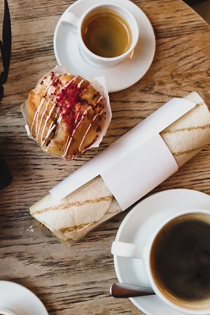 different sized cups of coffee with pastries on a table