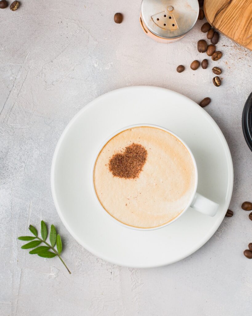 cup of coffee with a heart shaped cinnamon sprinkle on the foam