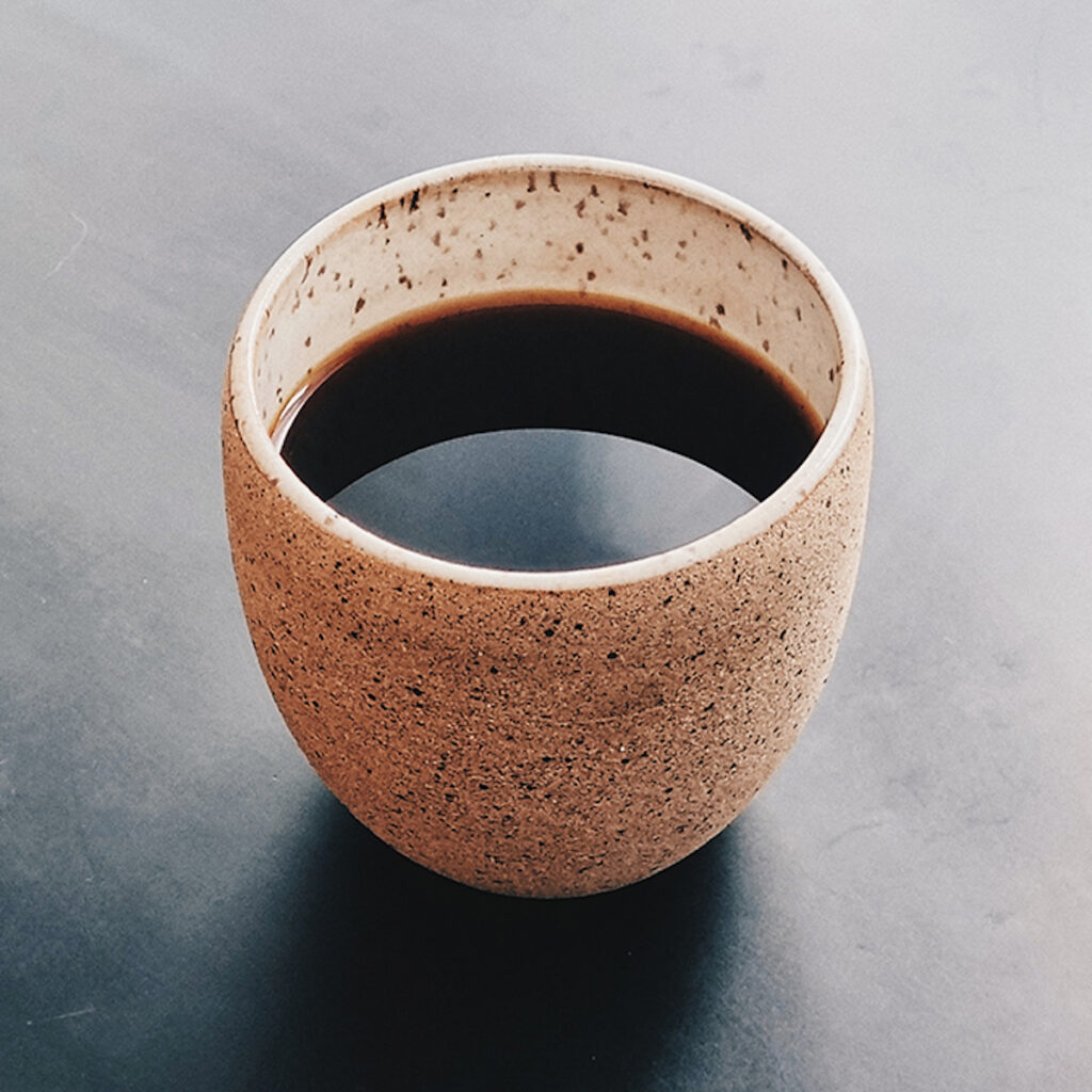 small earthenware ceramic cup of black coffee