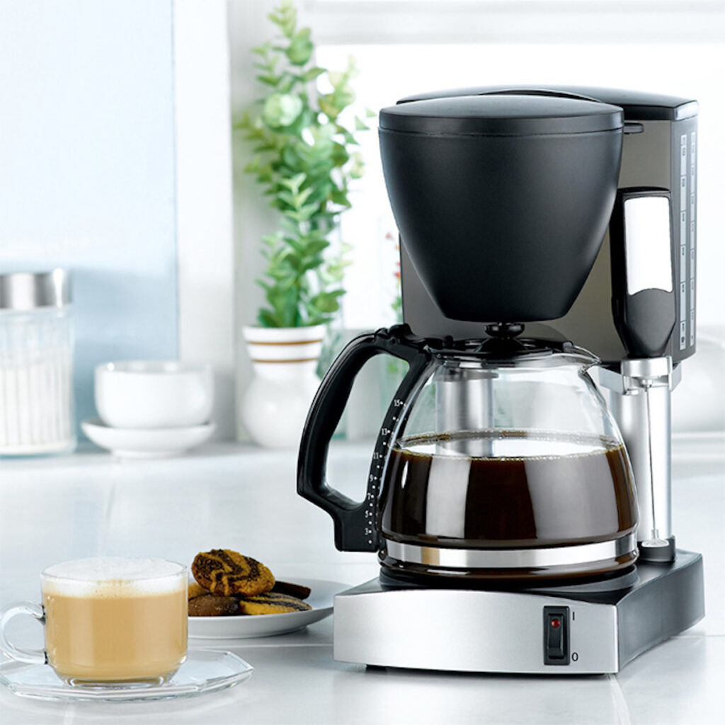 automatic coffee maker next to a cup of coffee