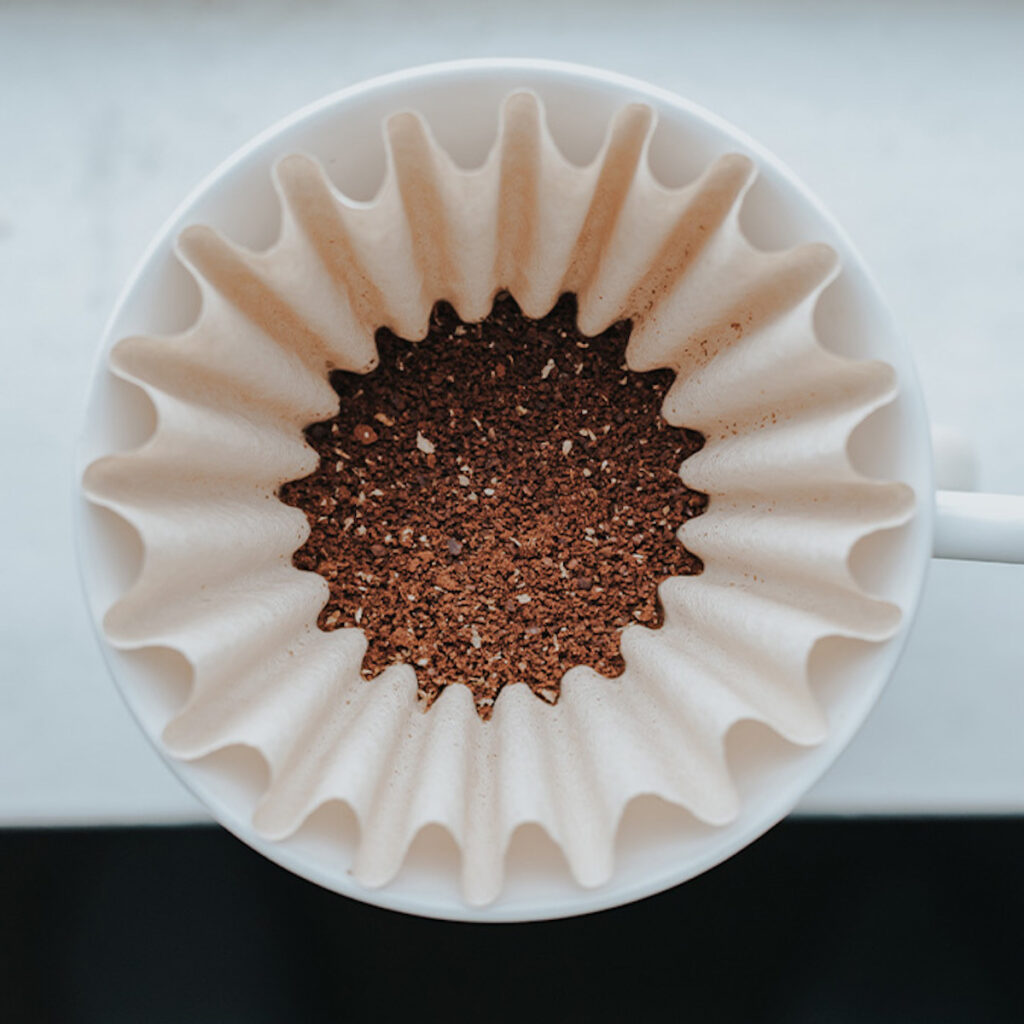 top vie of fresh coffee grounds in a coffee filter