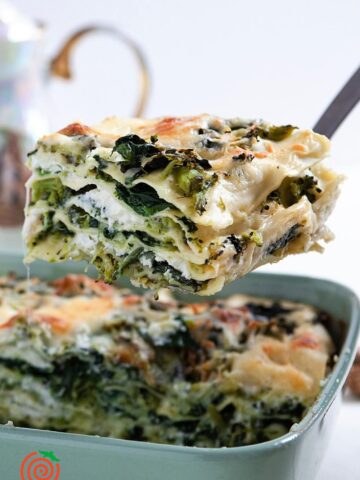 spatula lifting a serving of spinach broccoli lasagna from the pan