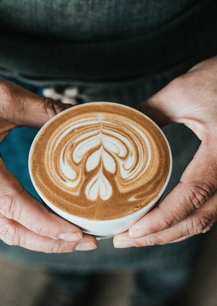 two hands holding a coffee breve