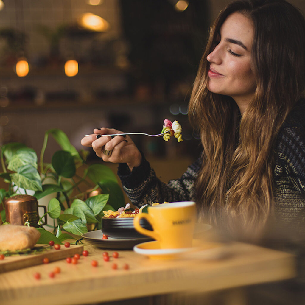 woman eating dinner with a coffee cup on the table