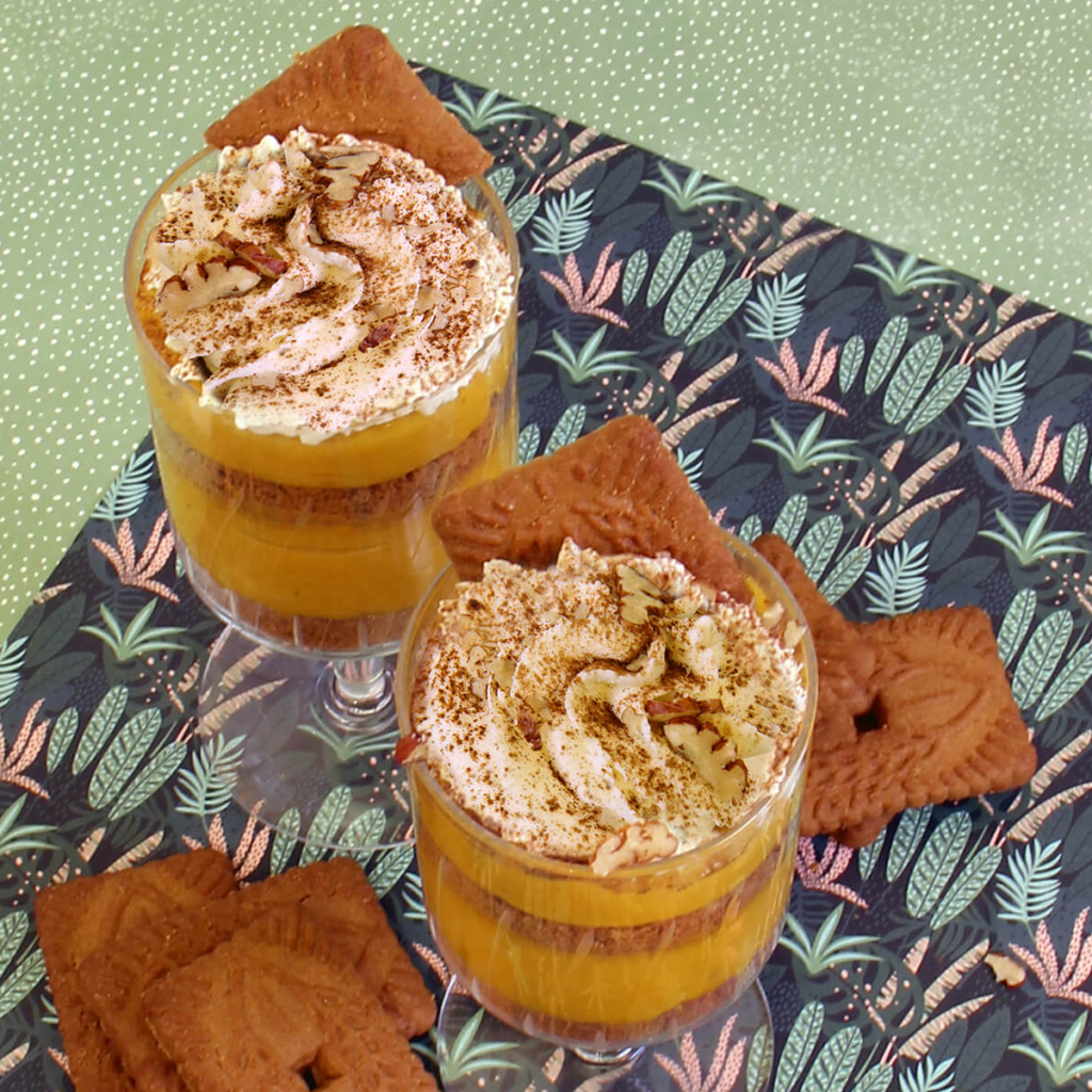 2 creamy pumpkin mousse dessert cups on a place mat with ginger snap cookies