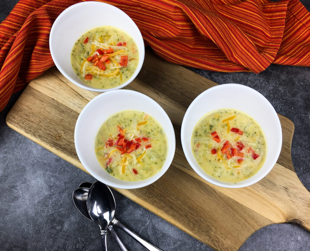 Instant Pot broccoli cheese soup from Flavor Portal recipe in three white bowls with two spoons