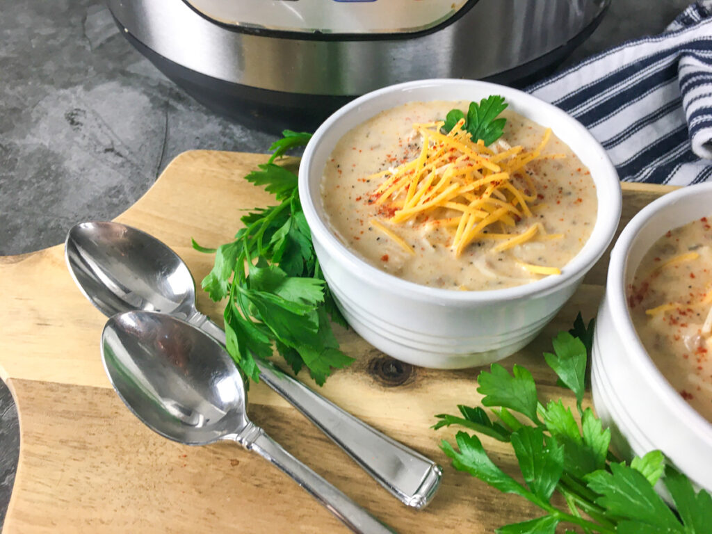 two bowls of Instant Pot Cheeseburger Soup from Flavor Portal recipe in front of Instant Pot