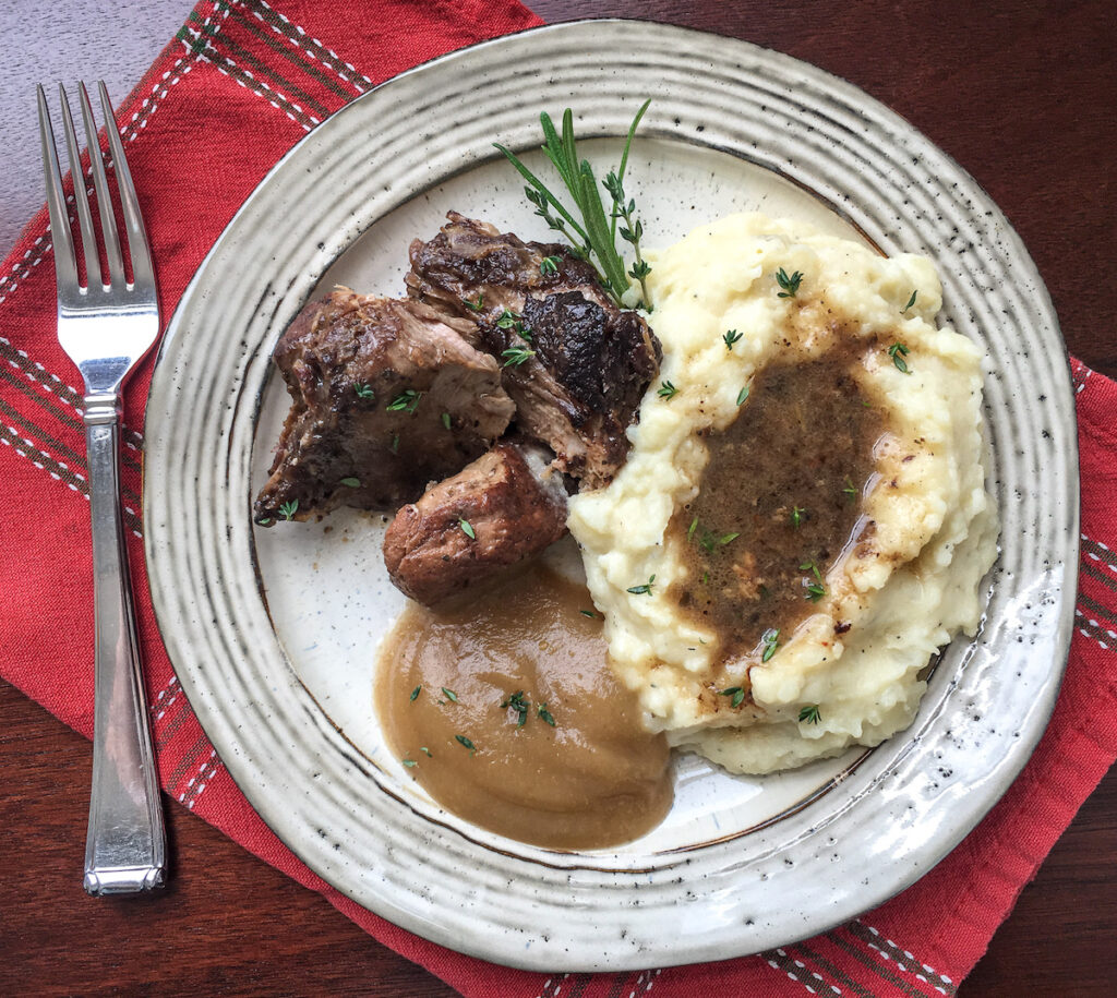 Instant Pot cocoa spiced pork roast from Flavor Portal recipe on a plate with mashed potatoes and gravy