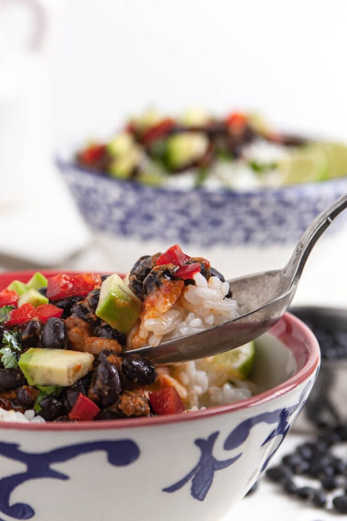 Instant Pot Cuban black beans from Flavor Portal recipe in a white bowl on a colorful saucer