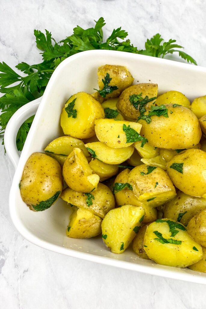Instant pot parsley potatoes in a white dish on white background recipe for flavor portal. 