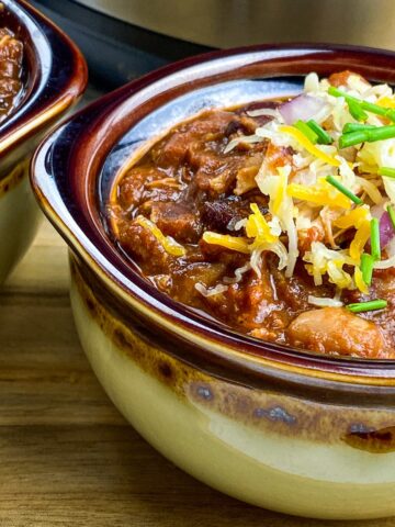 two bowls of Instant Pot pulled pork chili from flavor portal recipe in front of an instant pot