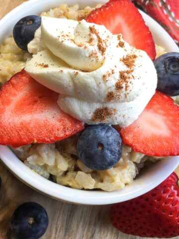 Instant Pot rice pudding from Flavor Portal recipe topped with sliced strawberries, blueberries and whipped cream sprinkled with cinnamon
