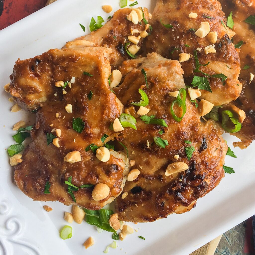 Instant Pot Thai chicken thighs on a white platter.