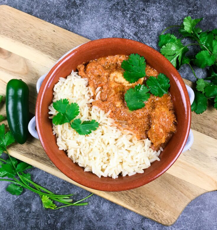 Instant Pot tiki masala from Flavor Portal recipe with rice in a brown ceramic bowl on a wood platter