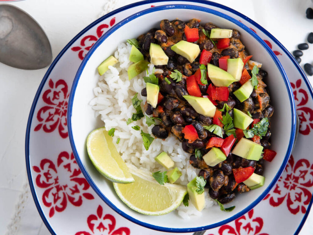 Instant Pot Cuban black beans from Flavor Portal recipe in a white bowl on a colorful saucer