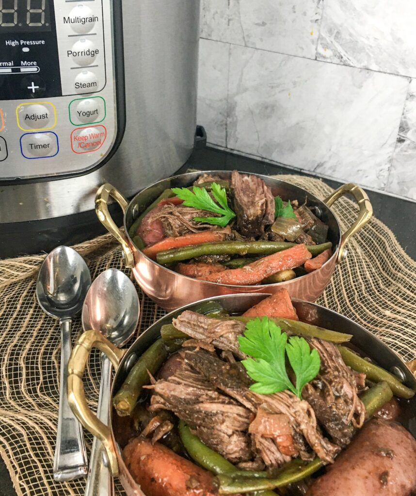 two bowls of Instant Pot traditional pot roast from Flavor Portal recipe in front of an Instant Pot