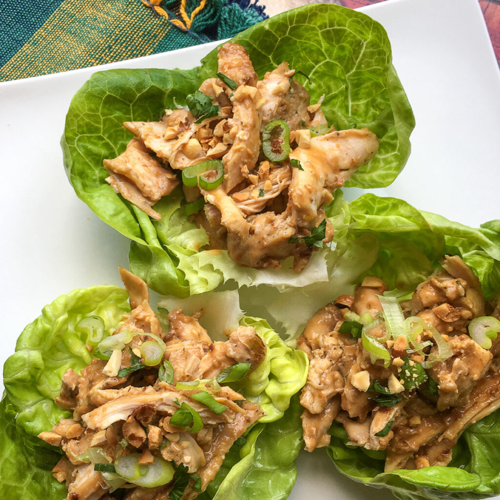 Three Tai chicken wraps on a white plate for Flavor Portal