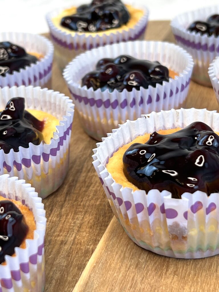 blueberry cheesecake tarts with vanilla wafers on a wooden platter