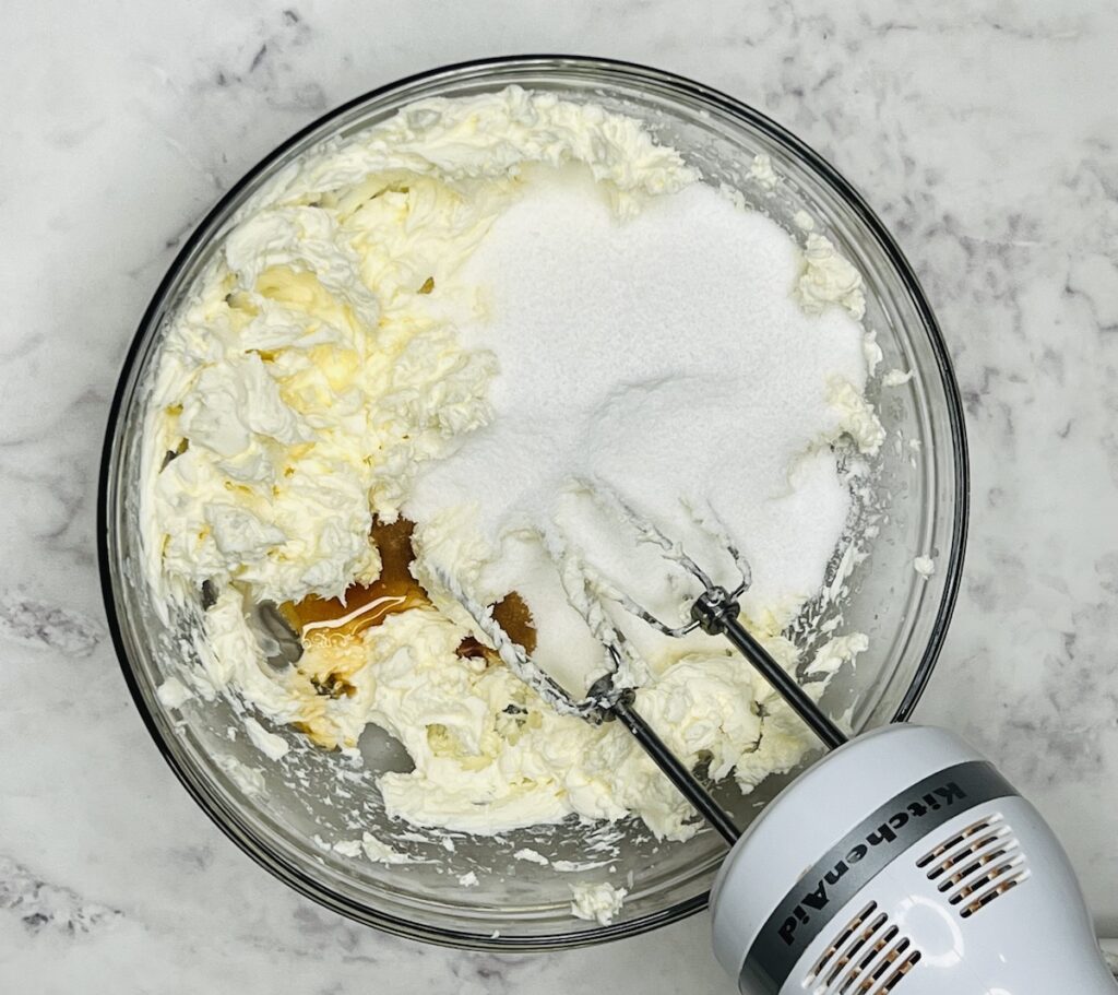 fluffed cream cheese in a bowl with sugar and vanilla