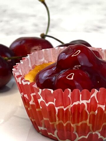 closeup of cherry cheesecake tart with vanilla wafers from flavor portal recipe next to fresh cherries