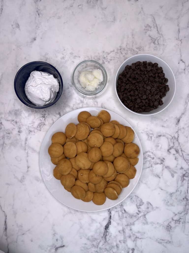 chocolate covered vanilla wafers ingredients in bowls - vanilla wafers, chocolate chips, marshmallow creme, coconut oil