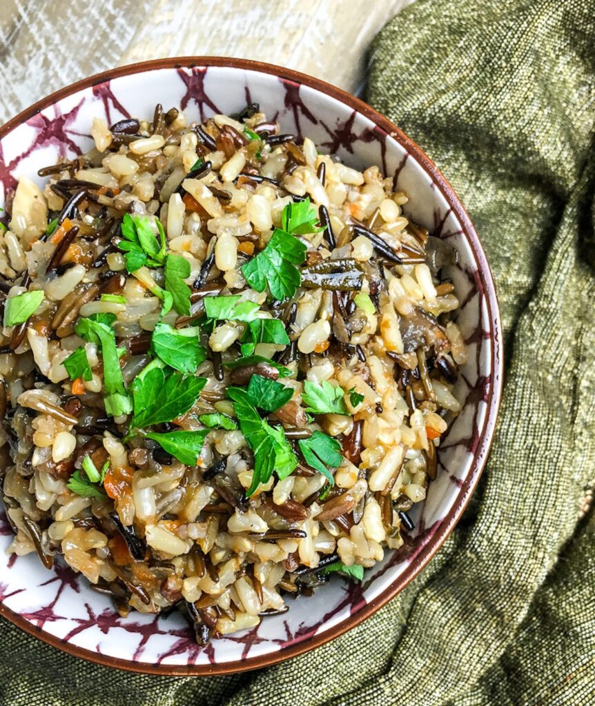 Instant Pot Wild Rice Pilaf from Flavor Portal recipe in ceramic bowl and garnished with chopped parsley