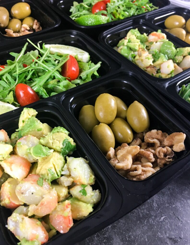 keto shrimp avocado salad from Flavor Portal recipe in a meal prep container with olives and nuts on the side