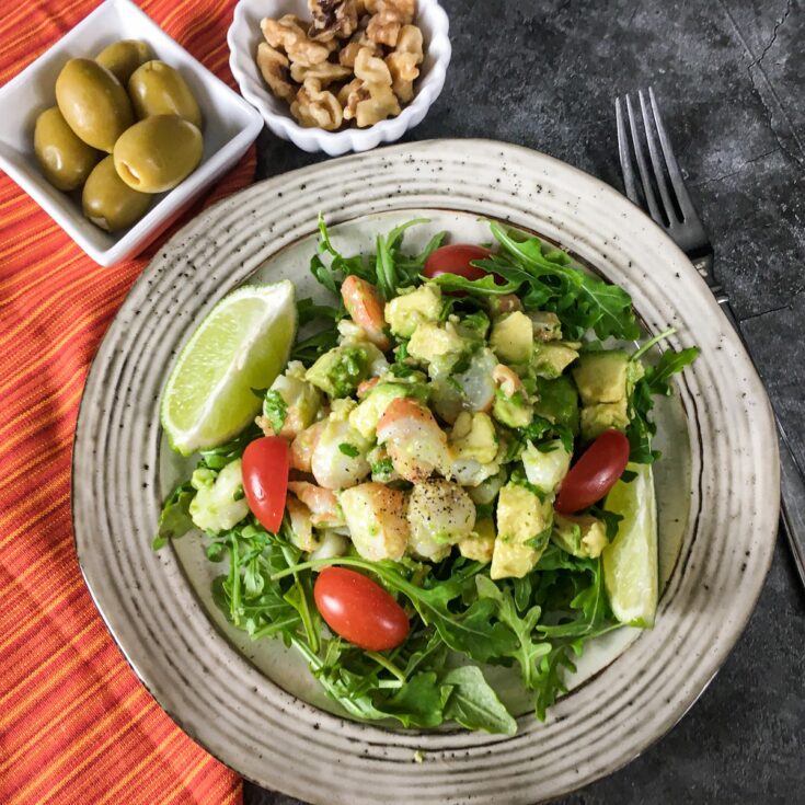 keto shrimp avocado salad from Flavor Portal recipe on a plate with olives and nuts on the side