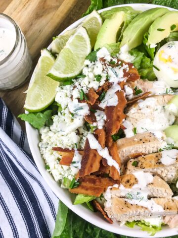 top view keto cobb salad from Flavor Portal recipe in a white bowl next to a jar of dressing