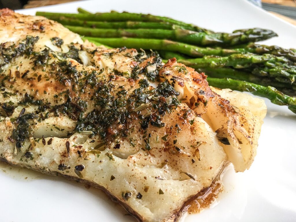 keto garlic herb butter cod from Flavor Portal recipe with asparagus on a white plate