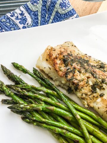 keto garlic herb butter cod from Flavor Portal recipe with asparagus on a white plate