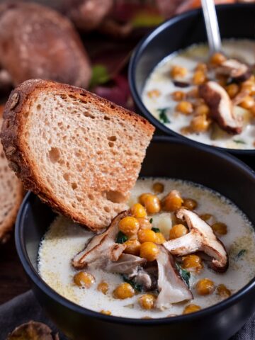 creamy hearty winter soup from Flavor Portal recipe in two bowls with slices of bread