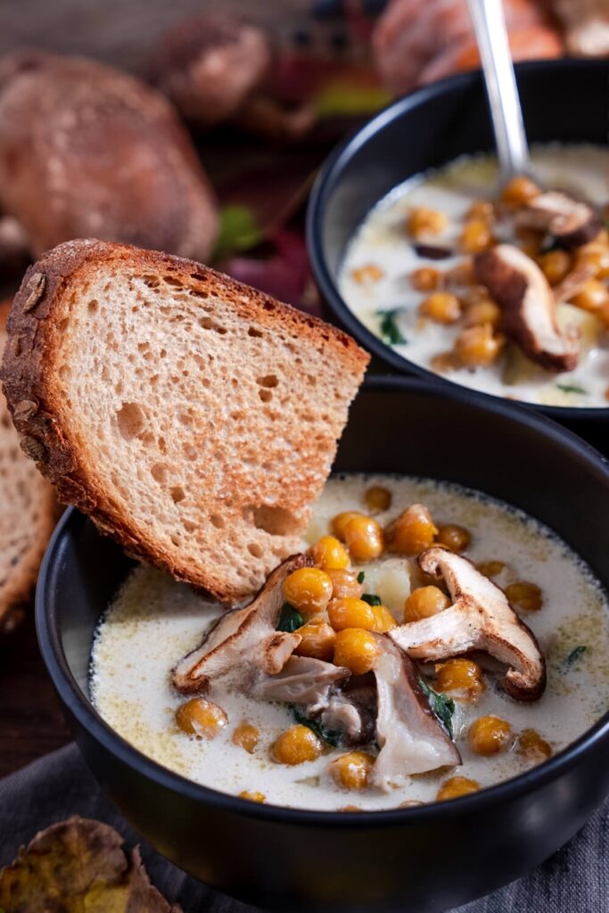 creamy hearty winter soup from Flavor Portal recipe in two bowls with slices of bread