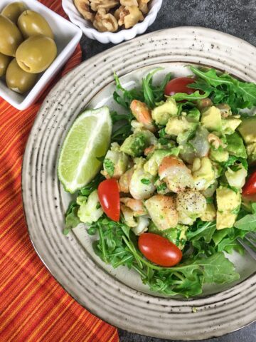keto shrimp avocado salad from Flavor Portal recipe on a plate with olives and nuts on the side