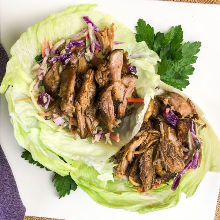 keto pulled pork from Flavor Portal recipe in lettuce wraps on a white plate garnished with parsley