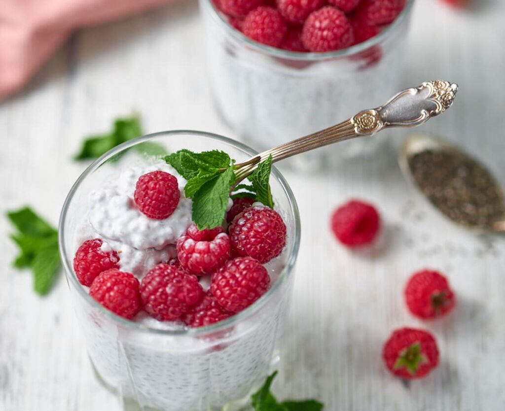 overnight keto chia pudding from Flavor Portal recipe in a glass topped with fresh raspberries and a sprig of mint