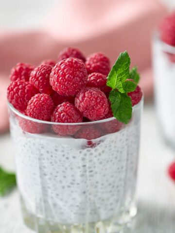 overnight keto chia pudding from Flavor Portal recipe in a glass topped with fresh raspberries and a sprig of mint