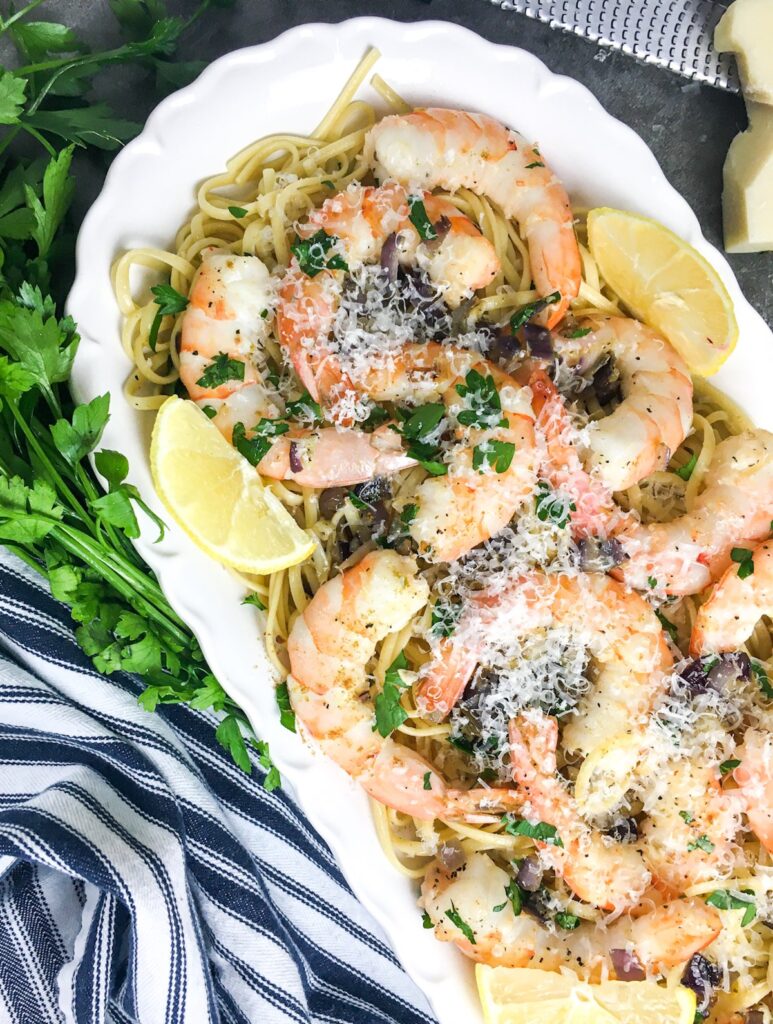 shrimp scampi from Flavor Portal recipe on a bed of noodles on a white platter