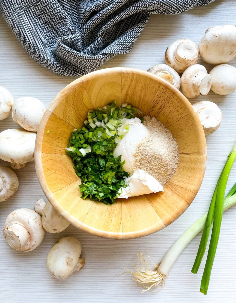 cream cheese, chopped scallions and garlic powder in a wooden bowl for cream cheese stuffed mushrooms from Flavor Portal recipe