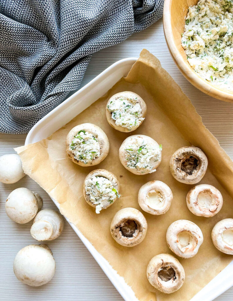 array of upside down mushrooms, half empty, half stuffed with herbed cream cheese mixture from herbed cream cheese stuffed mushroom Flavor Portal recipe