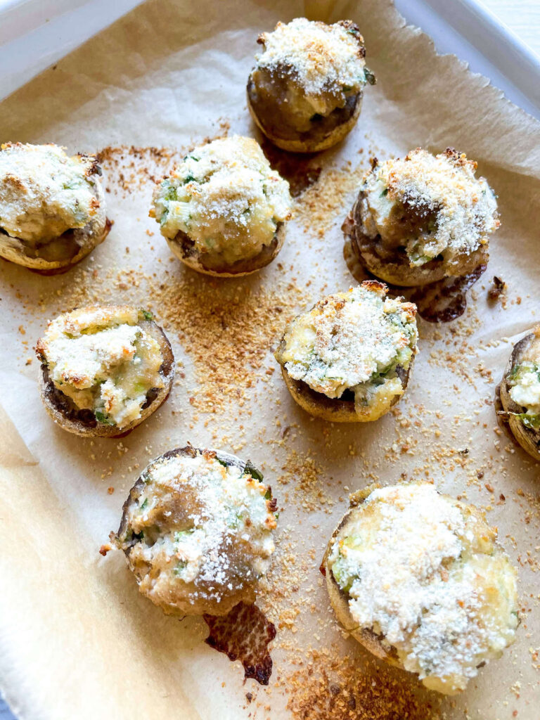 array of herbed cream cheese stuffed mushrooms from Flavor Portal recipe on parchment paper on a baking pan